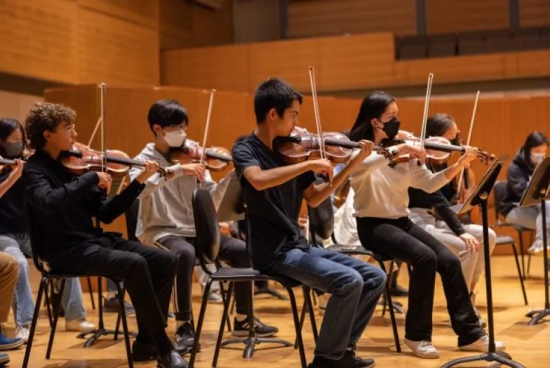 pre-college students in orchestra rehearsal