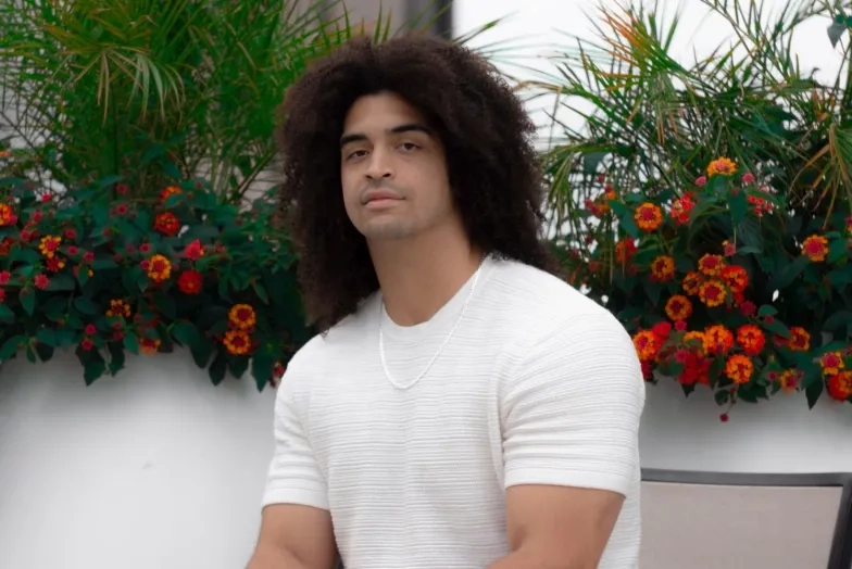 Xavier Muzik sits in front of plants