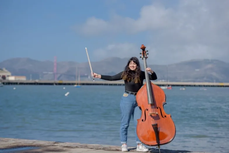 a bassist holds a bass at the pier