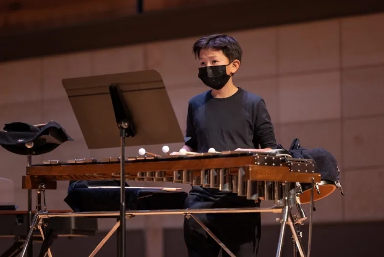 a pre-college percussionist watches the conductor