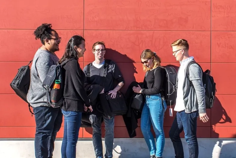 students stand in a group outside talking