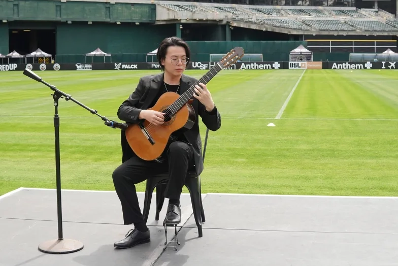 Mario To performing on guitar.