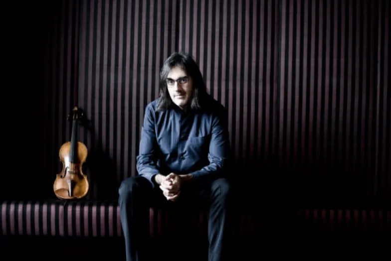 image of Leonidas Kavakos seated next to violin