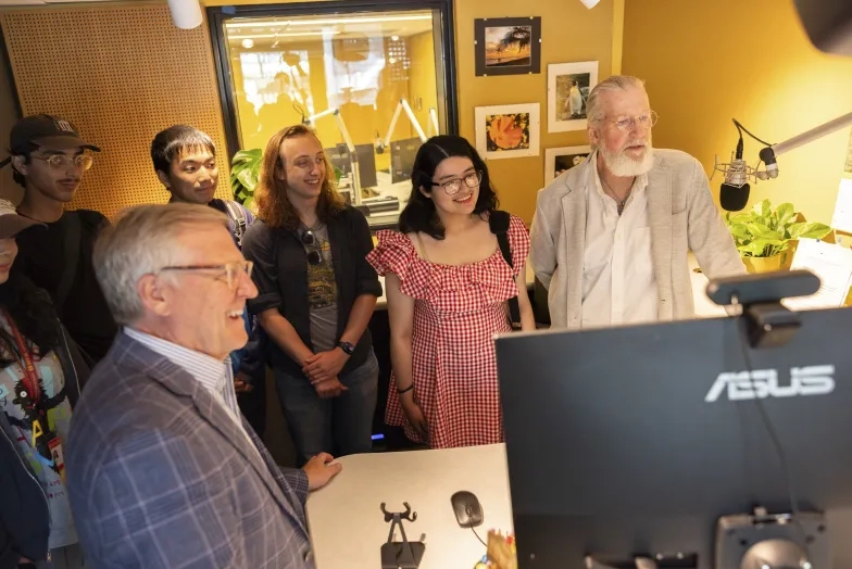 KDFC President Bill Lueth (left foreground) and Production Manager Stephen Page (at microphone) guide students through the KDFC studios.