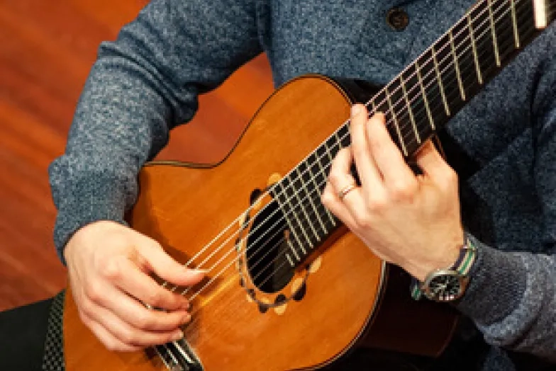 Guitar_300px.jpg a student playing a guitar close-up