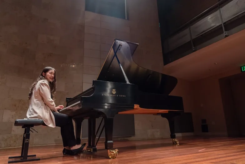 A pianist sits at the piano in the recital hall