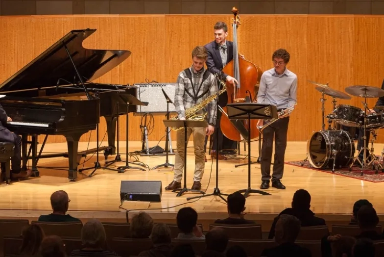 A photo of students with Simon Rowe performing