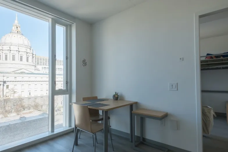 a room at the bowes center, showing the view of city hall as well as a bedroom