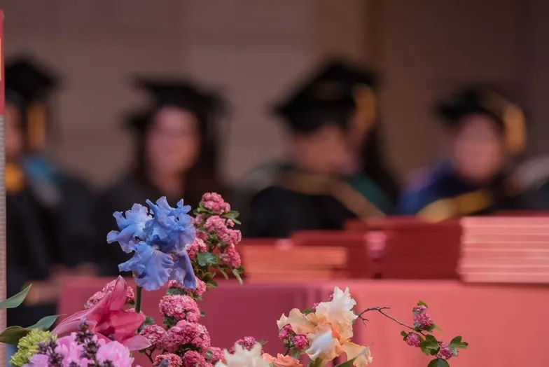 Empty stage with flowers and commencement banner