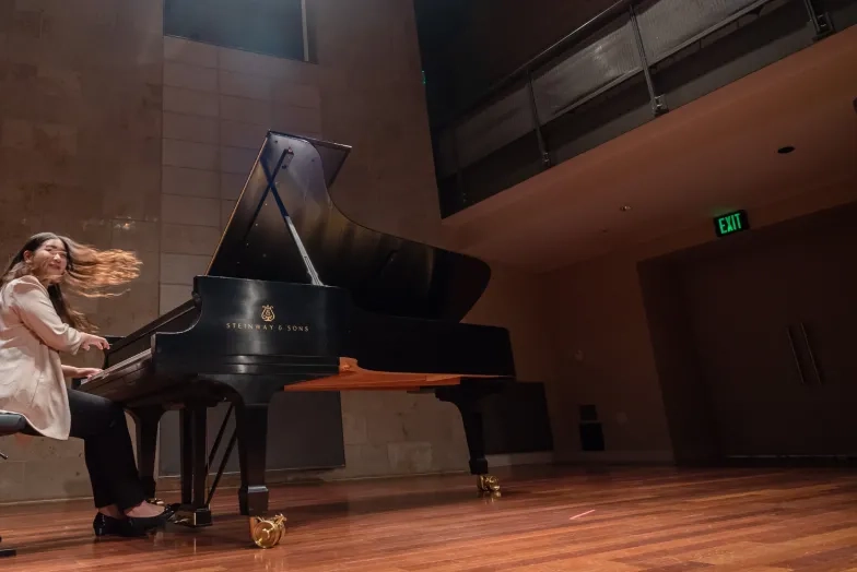 a student performing at the piano, hair is in motion