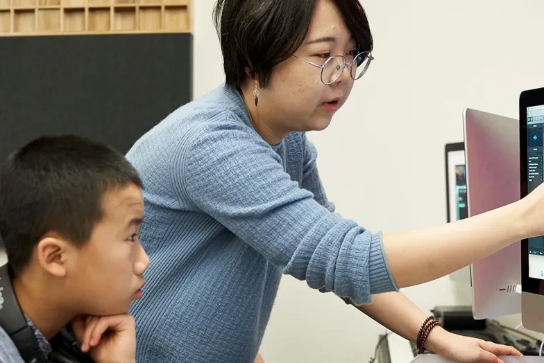 Pre-College Student working on computer with composition