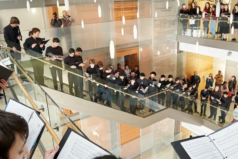 Pre-College Students singing inside SFCM. students wrapped around 2nd floor and down staircase