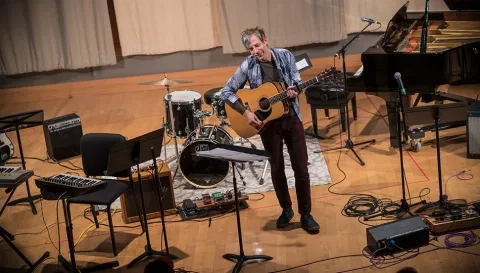 A man plays an acoustic guitar for Winter Term 09