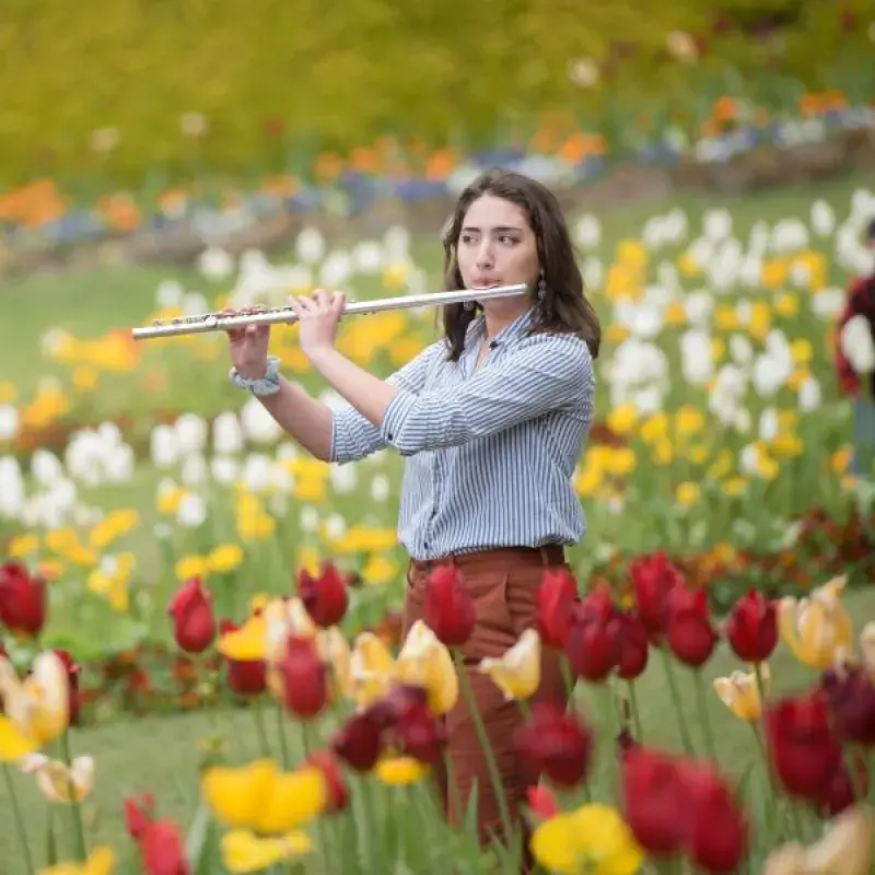 a flute student plays outside among the tulip gardens in san francisco